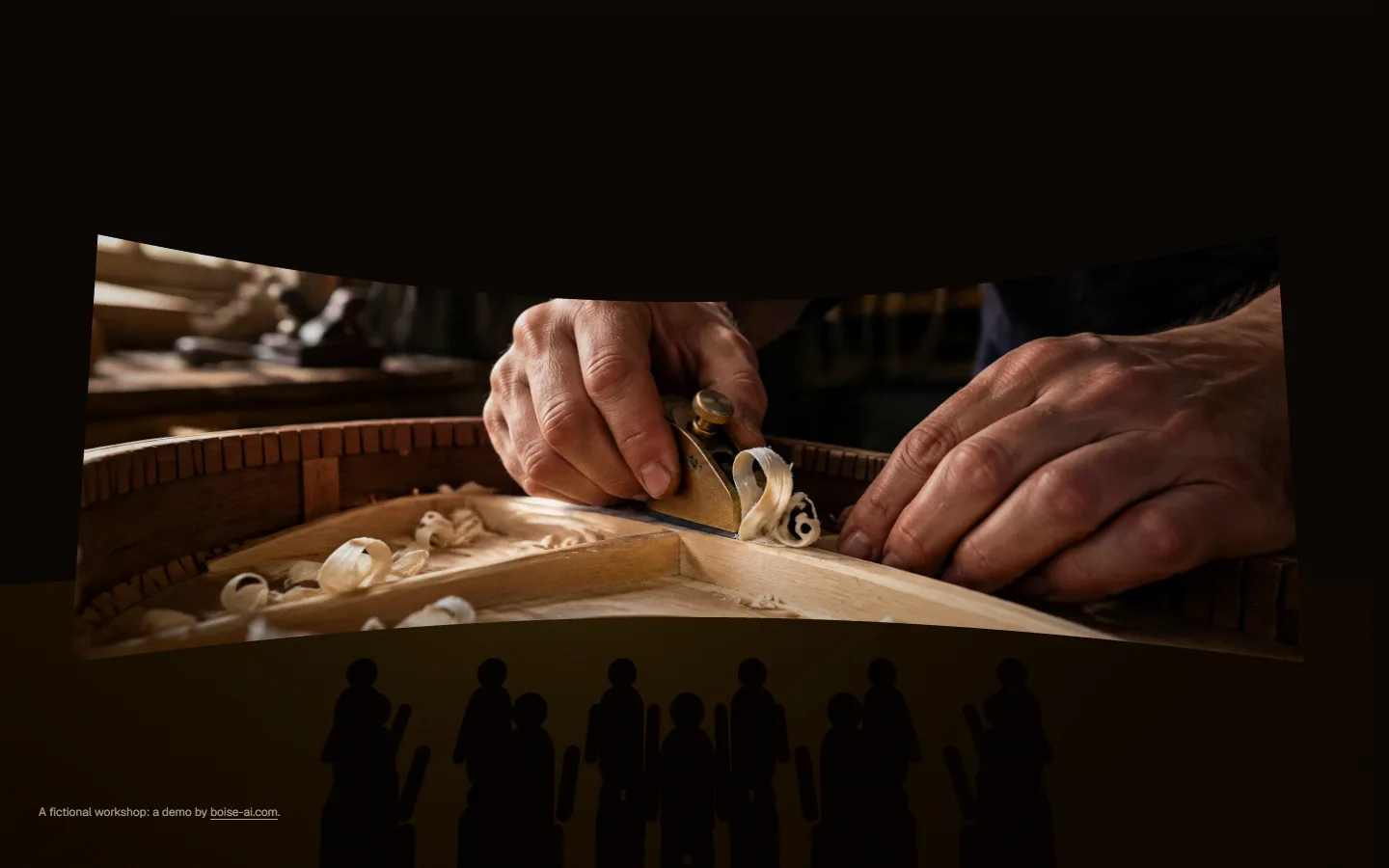 Silhouetted people watching a curved screen that shows a luthier's hands at the bench.